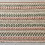 Crochet blanket with pink green and cream stripes