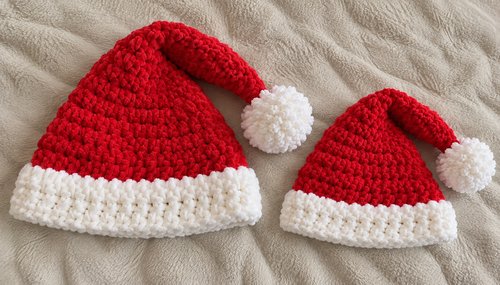 Two crochet Santa hats in adult and child sizes