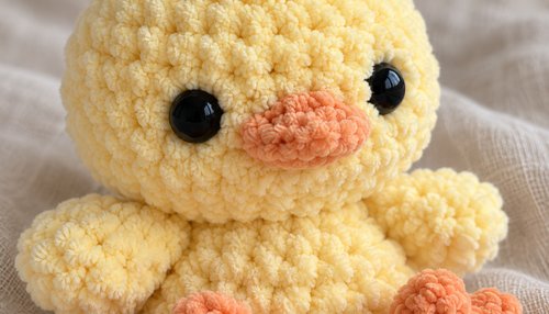 Close-up of a yellow crochet plushie chick face