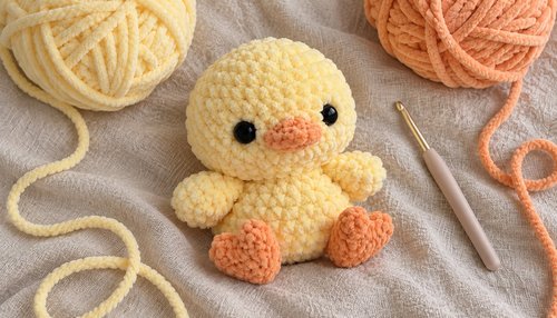 Yellow crochet plushie chick with yarn and crochet hook