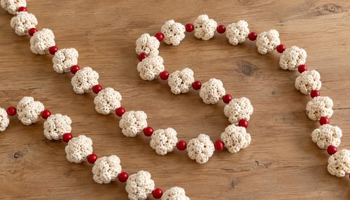 Finished crochet popcorn garland with cream popcorns and red wooden bead cranberries
