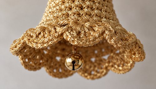 Close-up of scalloped rim and gold jingle clapper on a crochet bell ornament