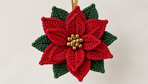 Crochet poinsettia flower with red bracts, green leaves and golden beaded center